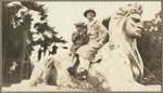 [Woman and boy sitting on a sphinx in Golden Gate Park]