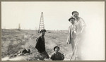 [Alfred Fuhrman and three men with oil wells seen behind them]