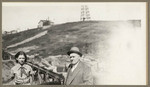 [Alfred Fuhrman and young woman standing in oil field area with pipeline seen behind them]