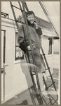 [Woman posing on ladder on the Admiral Farragut ship]