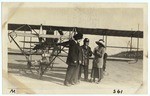 People in front of a biplane