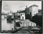 [Cargo barge and steamboats moored along Sacramento waterfront]