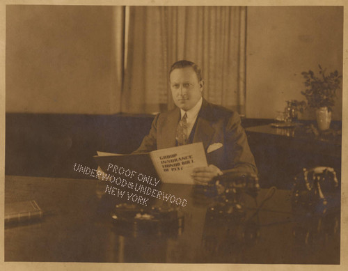 Portrait of Cecil Frankel, seated at his desk