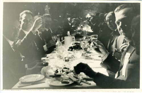 Closeup of Los Angeles Chamber of Commerce representatives at dining table, raising glasses