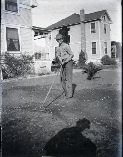 Young man with rake on Seventh Street, Claremont