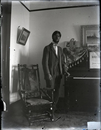 Edmund C. Boynton next to piano