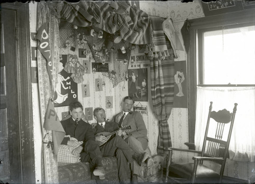 Student residence interior with students smoking pipes, Pomona College