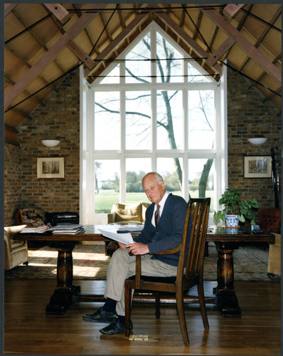 Charles Handy, color photo at desk near window