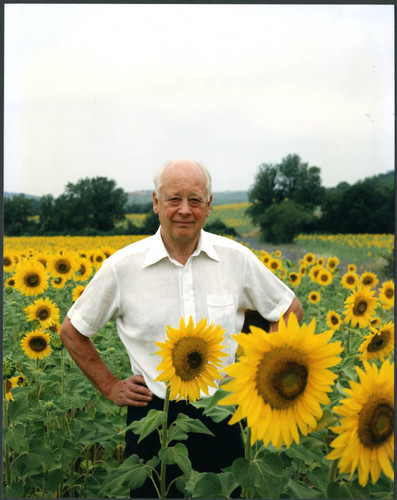 Charles Handy, color photo outside in field with sunflowers
