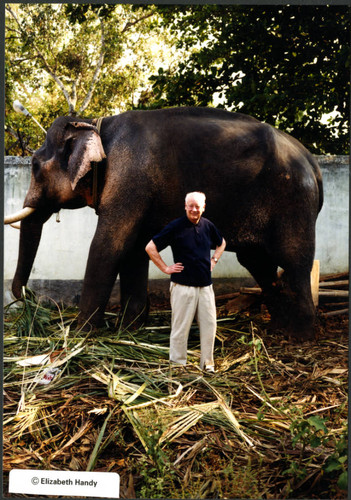 Charles Handy, color photo outside in front of an elephant