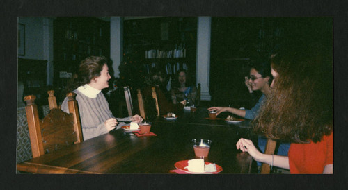 Students and staff eating together at a Christmas party in Denison Library, Scripps College