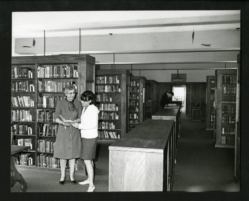 Dorothy Drake and a student read together in Drake Wing of Denison Library, Scripps College