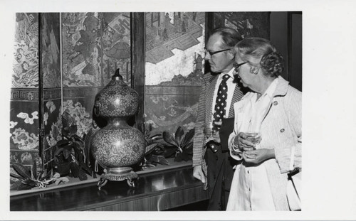 Man and woman observe a ceramic piece, Scripps College