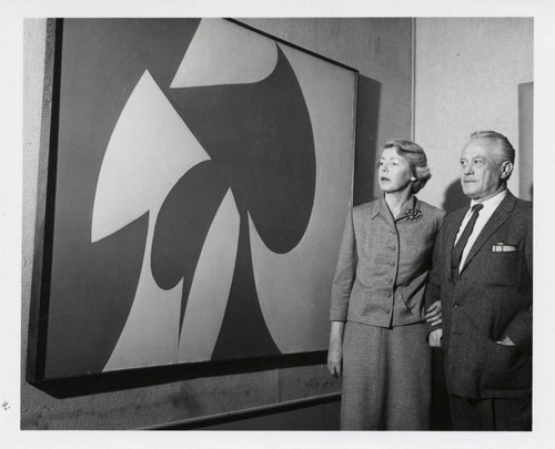 Woman and man observe painting, Scripps College