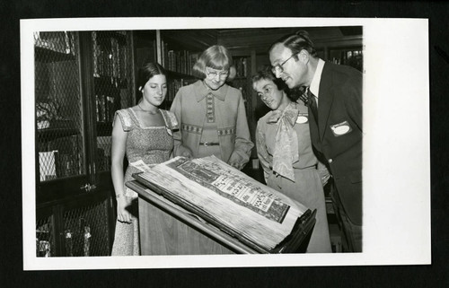 Student and Parents looking at a gradual on Parents Day 1975, Denison Library, Scripps College