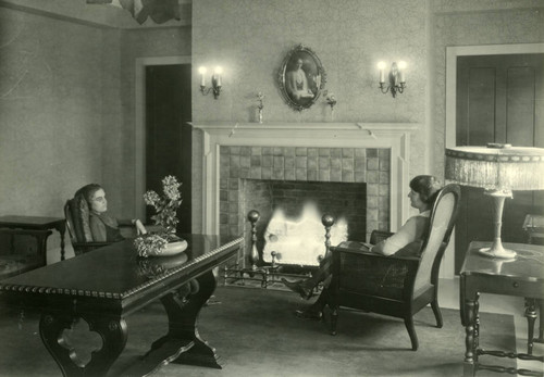 Women sitting near a fireplace, Pomona College