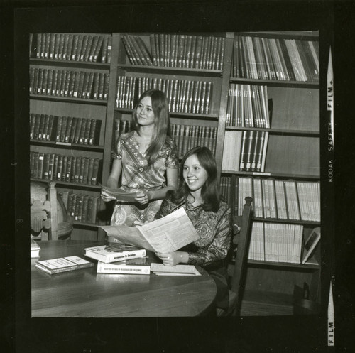 Scripps students smiling as they review their sociology notes in Denison Library, Scripps College