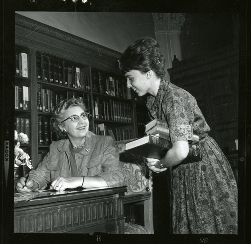 Dorothy Drake and a student librarian smile at each other, Scripps College