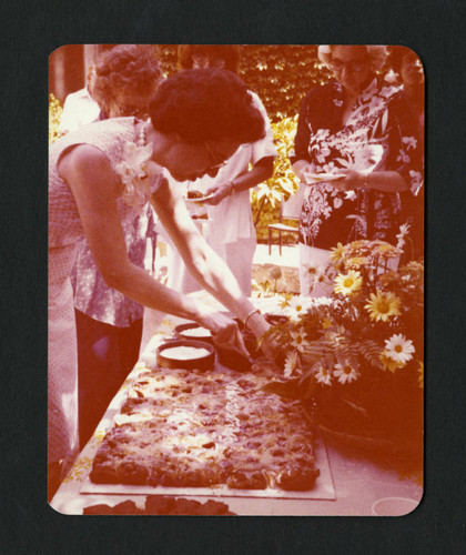 Jane Shanck cutting food at her 10th anniversary party, Scripps College