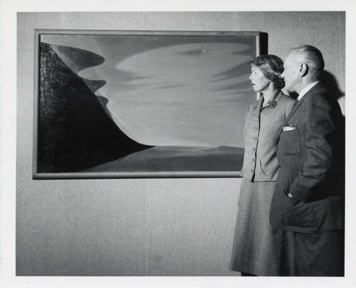 Woman and man observe painting, Scripps College