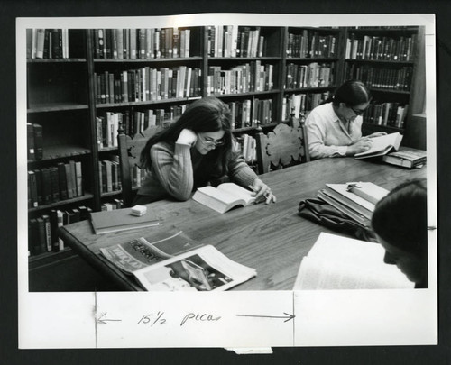 Three women study at a table in Denison Library, Scripps College