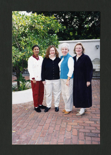 Librarians smiling together in Denison Library's beautiful courtyard, Scripps College