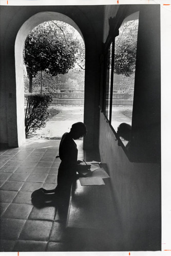 Student kneeling and writing, Scripps College