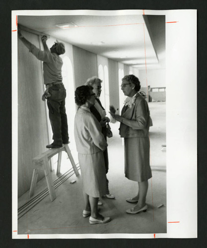 Dorothy Drake speaking with alumnae in the unfinished Drake Wing of Denison Library, Scripps College