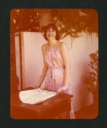 Sue Falck standing behind the Proclamation document, Scripps College