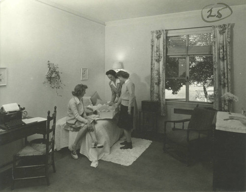 Women gathered around a box, dormitory room, Pomona College