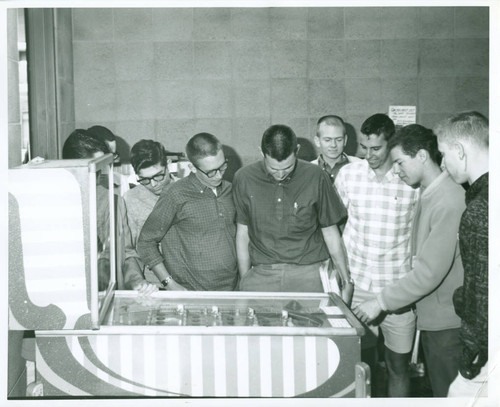 Students playing pinball machine, Harvey Mudd College