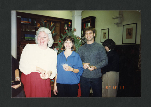 A librarian with students at Denison Library's Christmas Tea, Scripps College