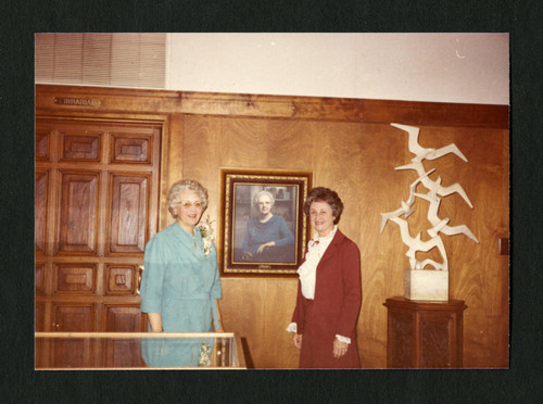 Dorothy Drake and Mildred te Groen standing by Dorothy's portrait in Denison Library, Scripps College