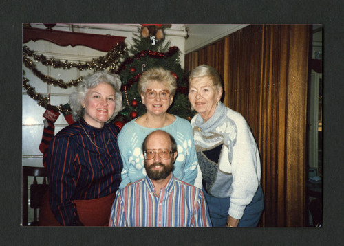 Librarians posing by a Christmas tree at the staff Christmas breakfast, Scripps College