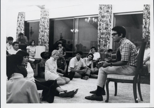 Man plays guitar for group, Scripps College