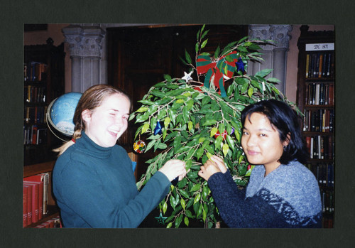 Scripps students decorating Denison Library's tree for the Scripps Christmas tea, Scripps College