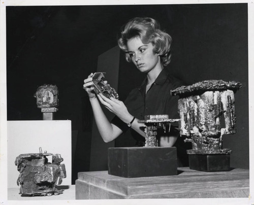 Woman examines sculpture, Scripps College