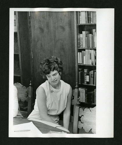 Scripps student pondering her paper in Denison Library, Scripps College