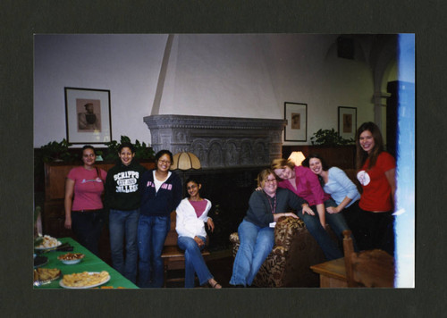 Denison Library staff sitting together at the 2004 Staff Christmas Party, Scripps College