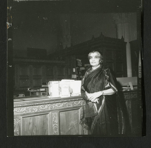 Miss Ivinne leaning against Denison Library's front desk, Scripps College