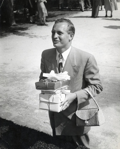 Man holding gifts, Scripps College
