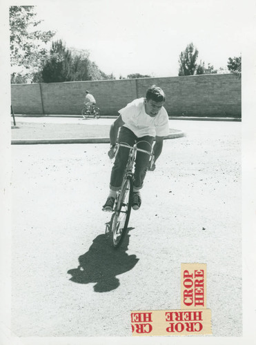 Student riding bicycle, Harvey Mudd College