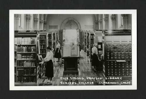 Librarians arranging books in Denison Library's main reading room, Scripps College