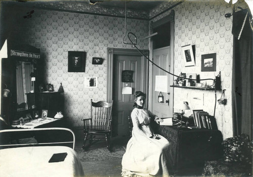 Woman seated at a desk, dormitory room, Pomona College