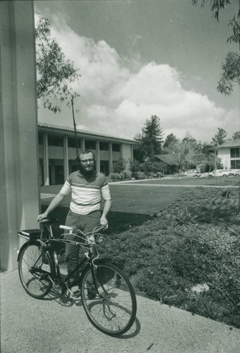 Man and bicycle outside McManus Hall