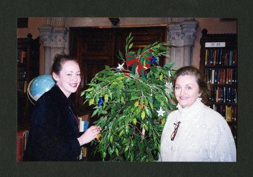 A Scripps student and librarian decorate Denison Library's Christmas tree together, Scripps College