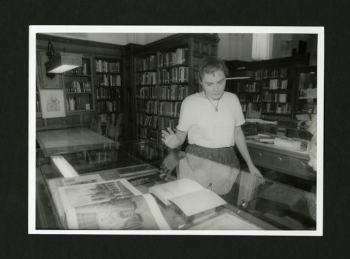 1996 Slocum Award winner Alice Pierce looking at a display case in Denison Library, Scripps College