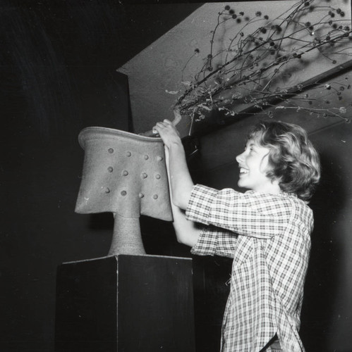 Woman making vase arrangement, Scripps College