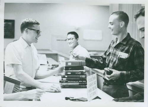 Student checking out books, Harvey Mudd College