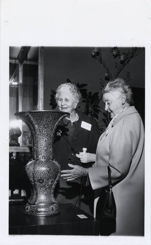 Two women observe a vase, Scripps College